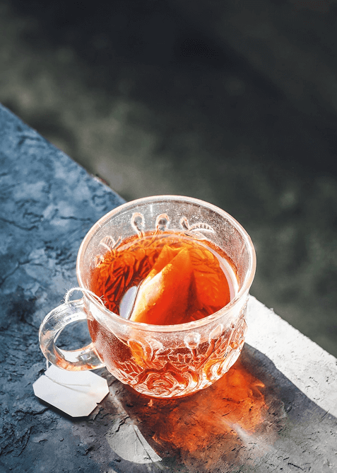 Glass cup of tea with lemon slice.